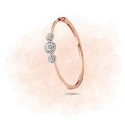 Rose gold bracelet with three diamonds on a light pink background