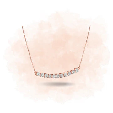 Rose gold necklace with small diamonds on a light pink background